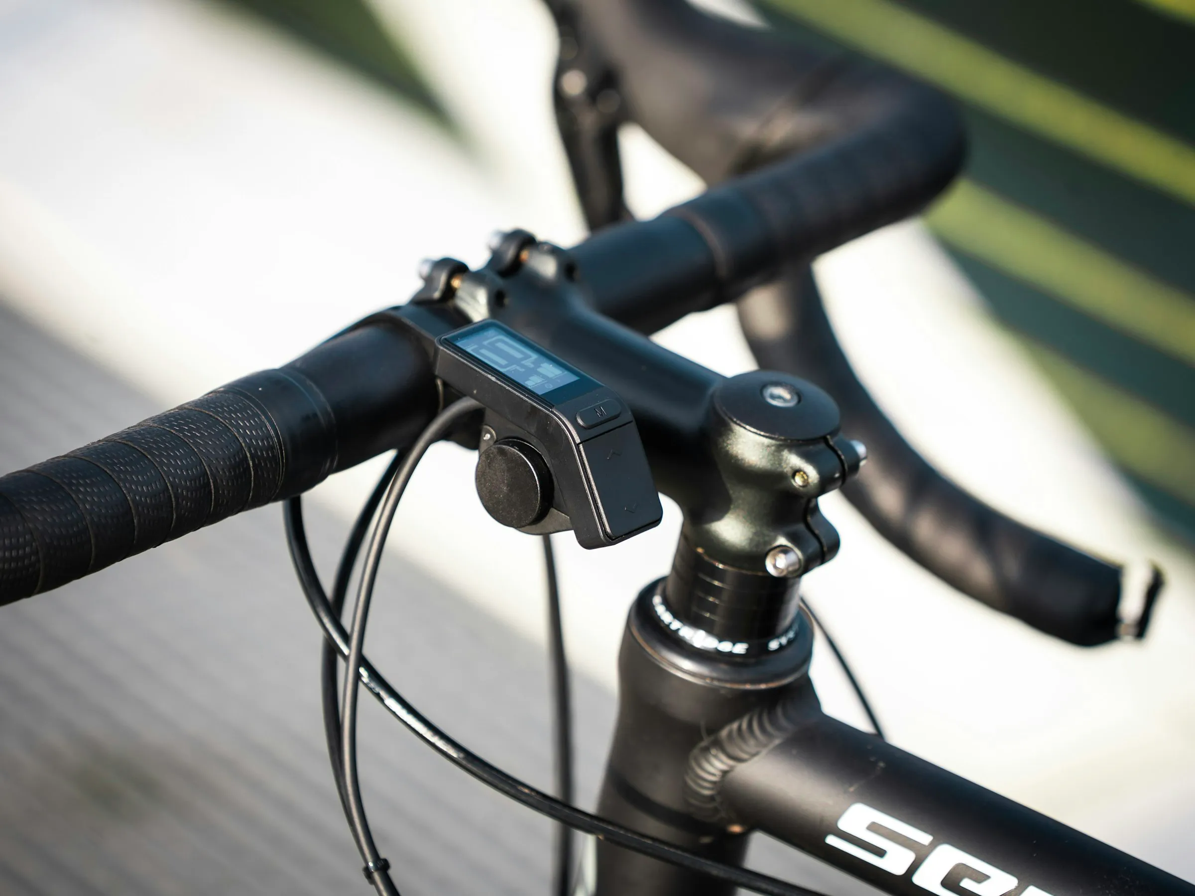 Road bike handlebar with a small cycling computer mounted in the center